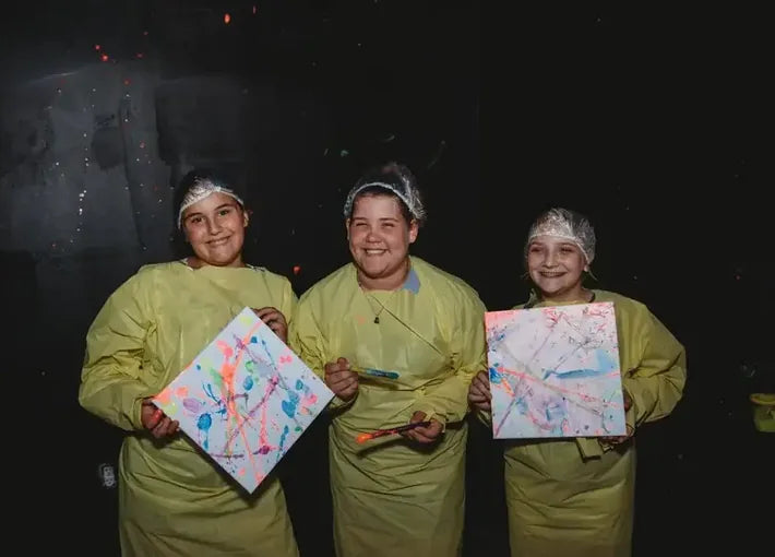 Children pose with their finished paint canvas after painting in the splash room in mineral wells texas